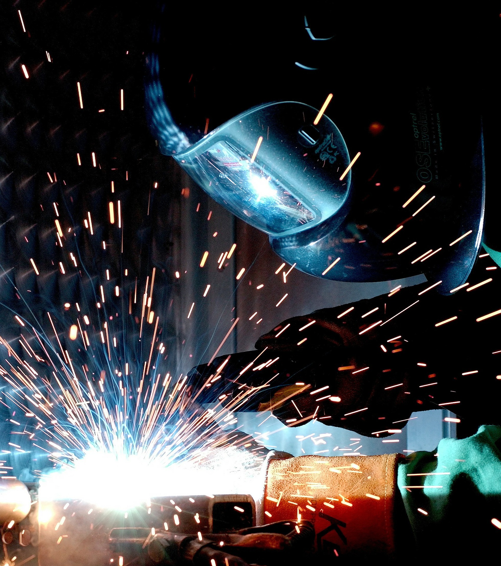 Schweißen mit Schweißhelm und Funkenflug für Industriemeister Metall